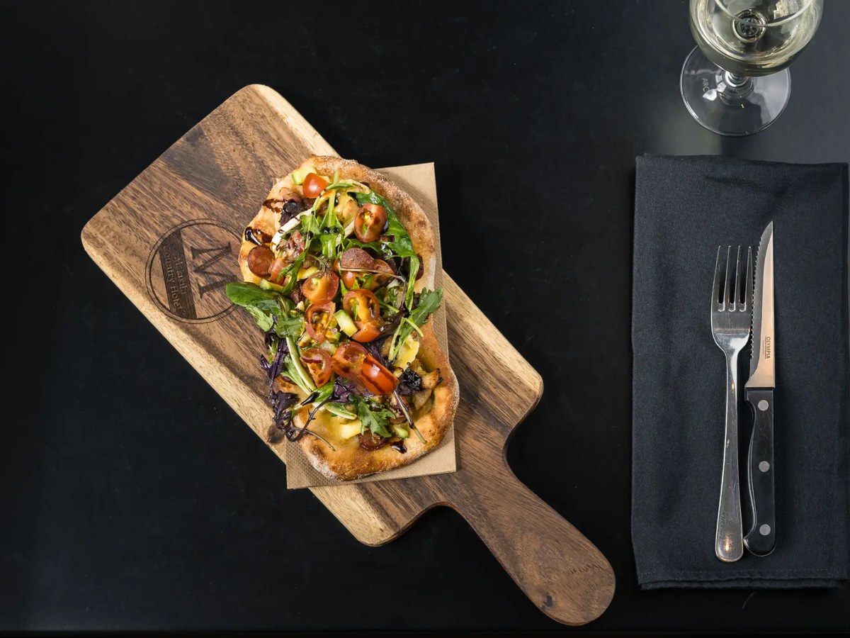 Loaded flatbread on branded wooden board
